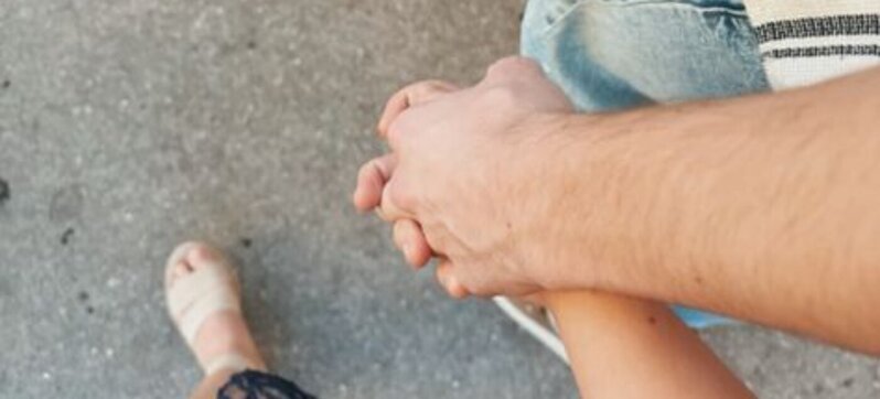 Twee mensen houden elkaars hand vast